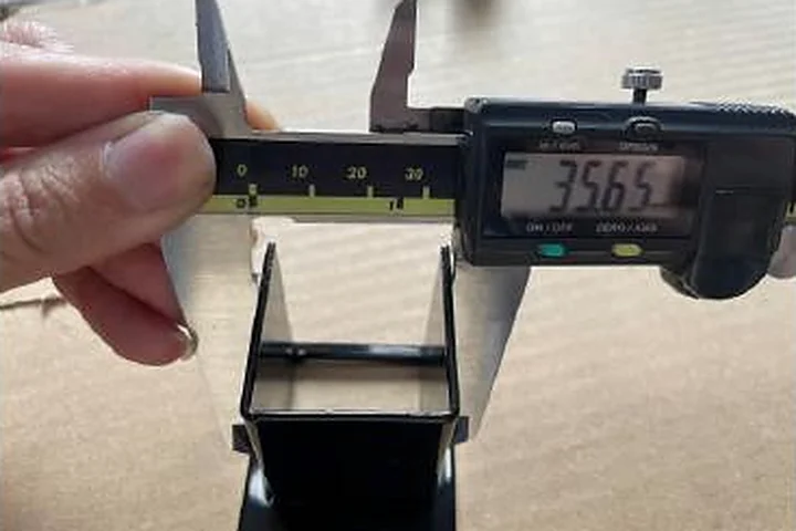 Caliper measurement of a fence post bracket during pre-shipment inspection