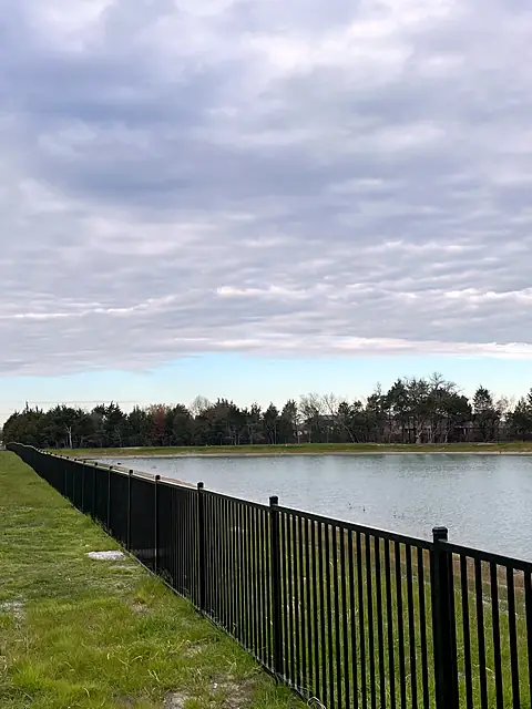Flat-top steel fence along a retention pond
